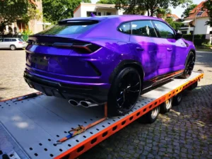 Laweta przewożąca fioletowe Lamborghini Urus na platformie